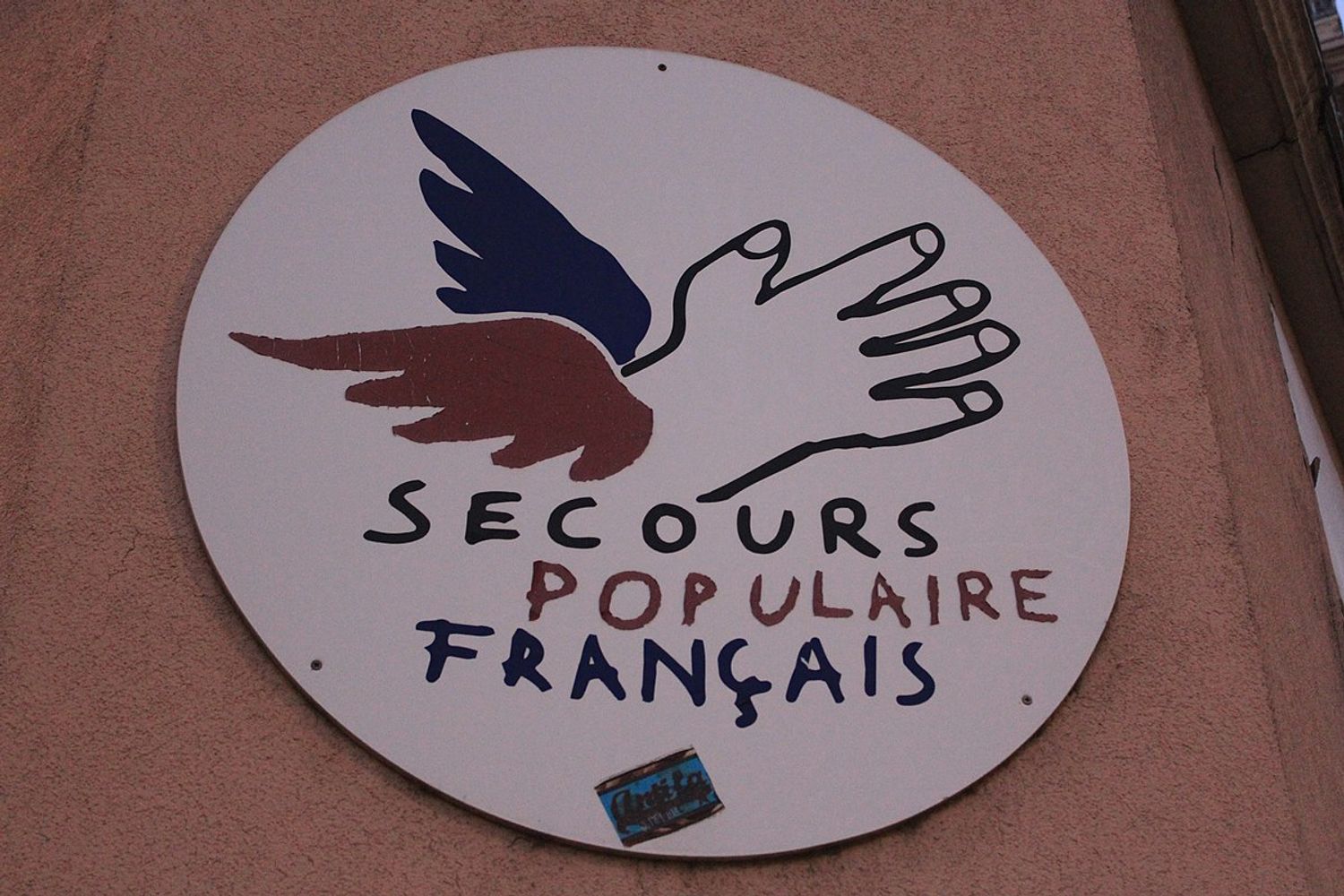 Logo Secours Populaire sur un mur d'un local